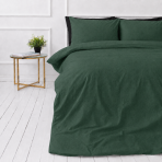 Leinen bettwäsche "Linen Dark Green". Bettwäsche einfarbig, 135/140x200 cm, 150x200 cm, 155/160x200 cm, 180x200 cm, 200x200 cm, 200x220 cm, 220x240 cm. Dunkelgrünes leinenbettwäscheset auf weißem boden mit nachttisch und zimmerpflanze.